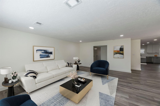 living room featuring wood-type flooring and a textured ceiling