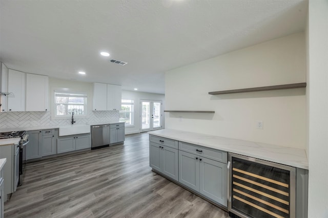 kitchen featuring stainless steel appliances, gray cabinetry, tasteful backsplash, wine cooler, and sink