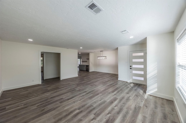 unfurnished living room featuring wood-type flooring and a textured ceiling