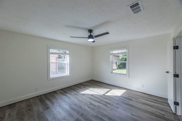 empty room with ceiling fan, dark hardwood / wood-style flooring, and a textured ceiling