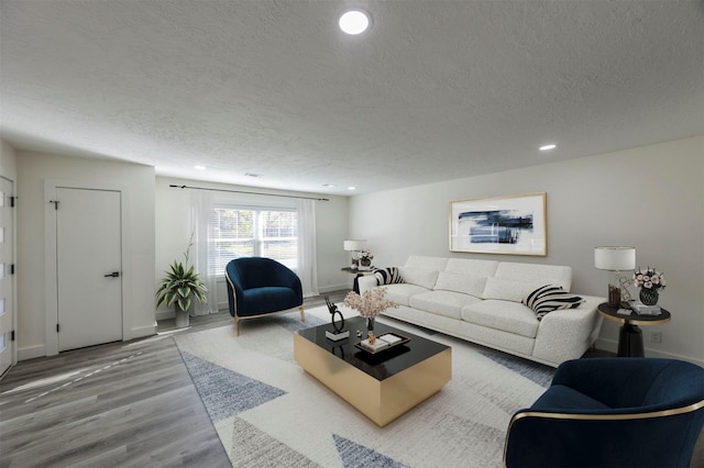 living room with wood-type flooring and a textured ceiling