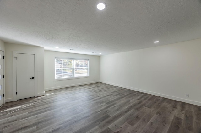 empty room featuring dark hardwood / wood-style flooring and a textured ceiling