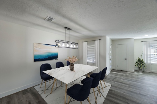 dining area featuring a textured ceiling and hardwood / wood-style flooring