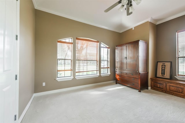 unfurnished bedroom featuring ceiling fan, crown molding, and light colored carpet