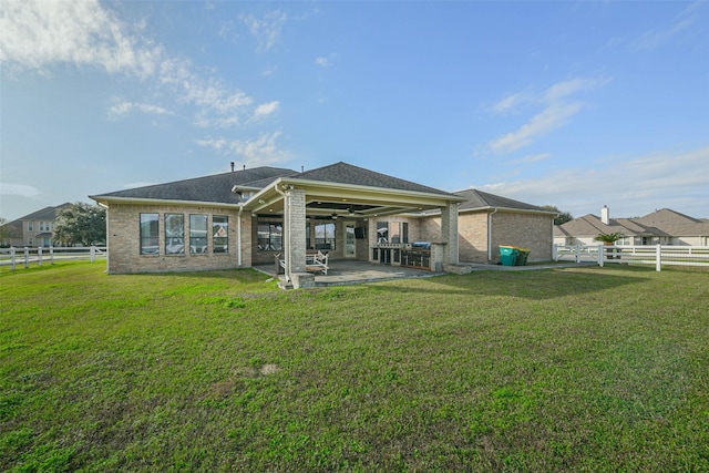 rear view of property featuring a patio and a lawn