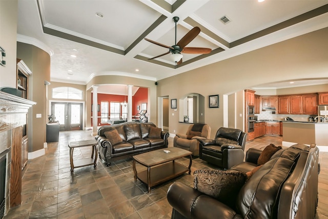 living room featuring ceiling fan, coffered ceiling, beamed ceiling, decorative columns, and a fireplace