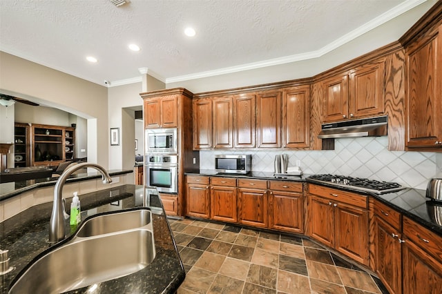 kitchen with backsplash, sink, ceiling fan, a textured ceiling, and stainless steel appliances