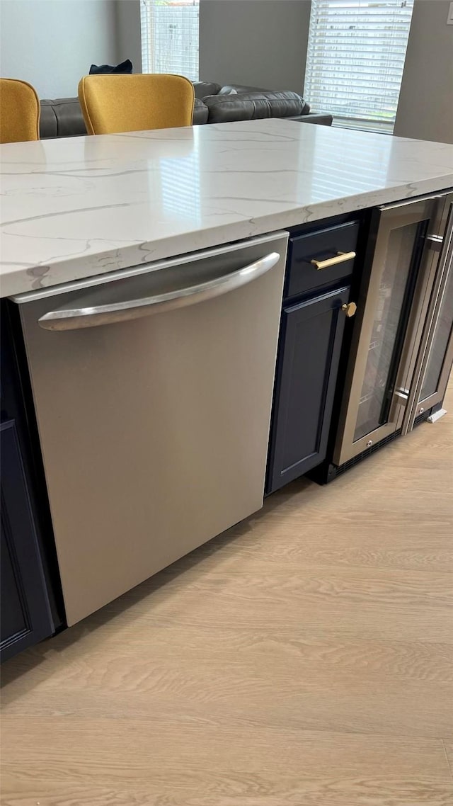 kitchen with a wealth of natural light, light wood-type flooring, dishwasher, and wine cooler