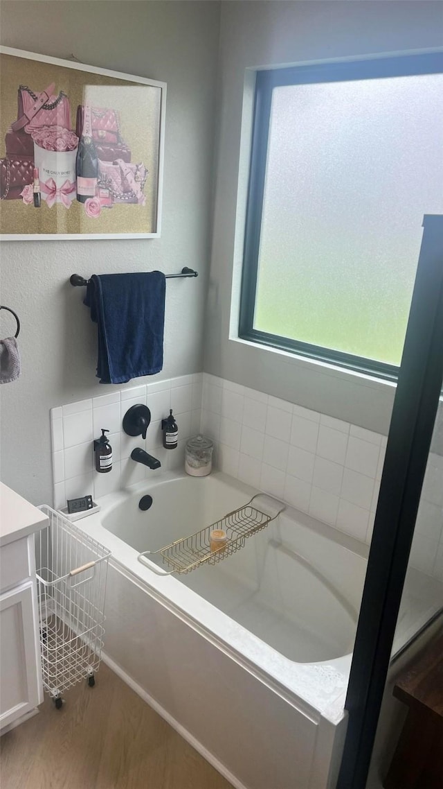 bathroom featuring wood-type flooring, vanity, and a tub