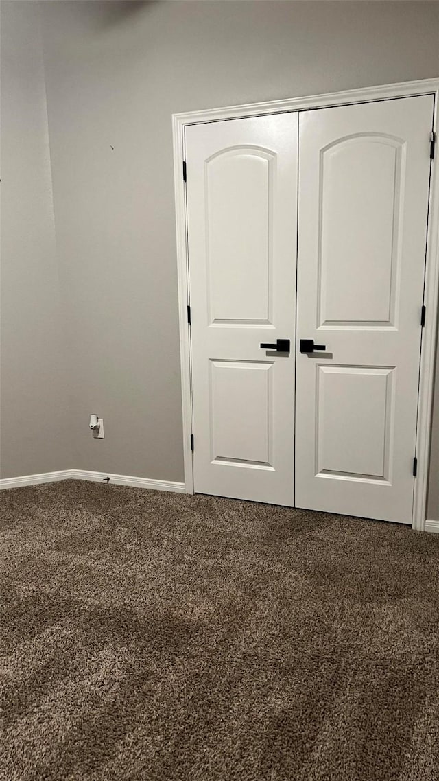 unfurnished bedroom featuring carpet flooring and a closet