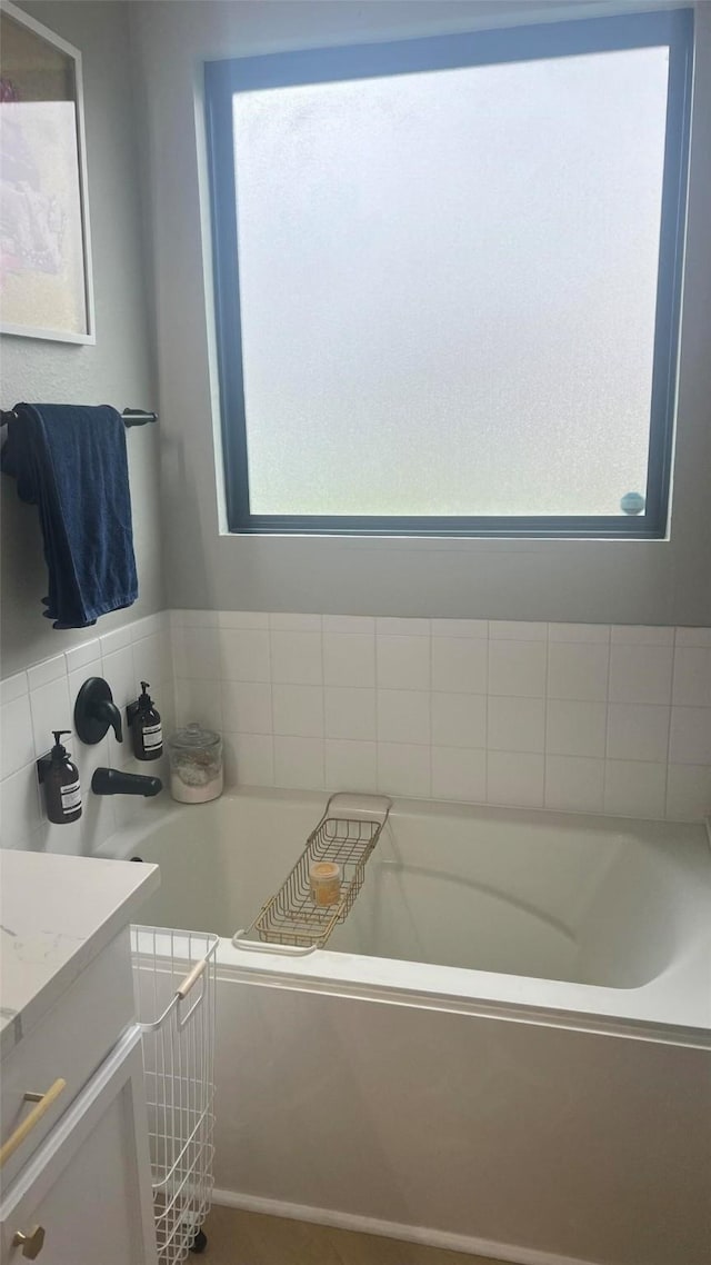 bathroom featuring vanity, a wealth of natural light, and a tub