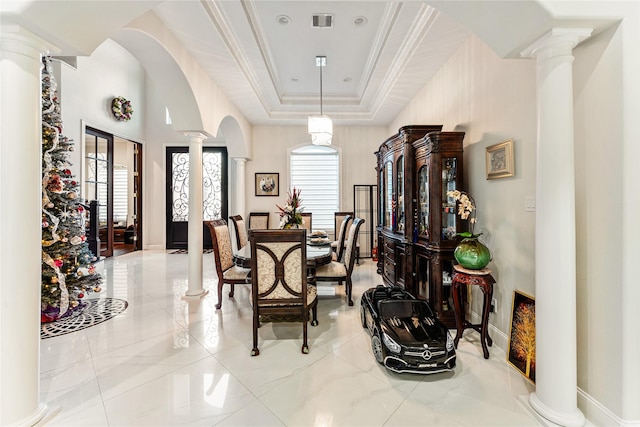 dining space with ornate columns, crown molding, and a tray ceiling