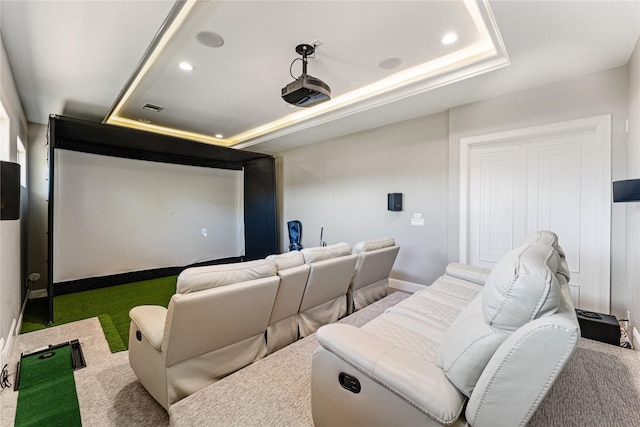 home theater with a raised ceiling, golf simulator, and carpet