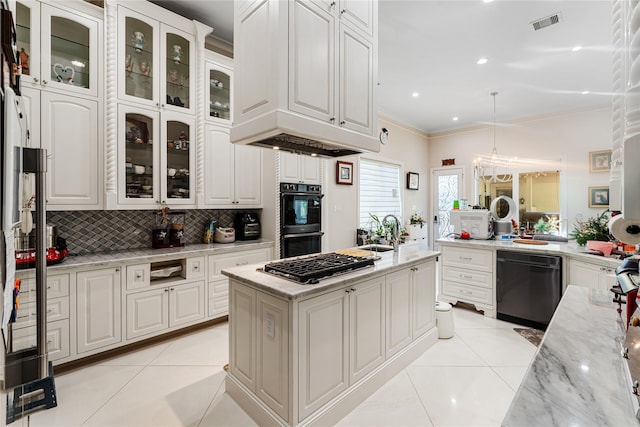 kitchen featuring light stone counters, white cabinets, decorative light fixtures, and black appliances