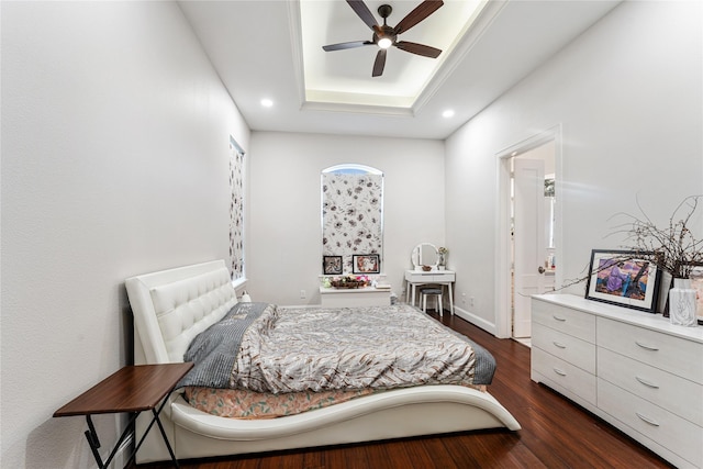 bedroom with dark wood-type flooring and a tray ceiling