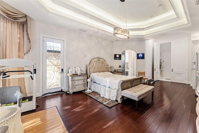 bedroom featuring dark wood-type flooring and a tray ceiling