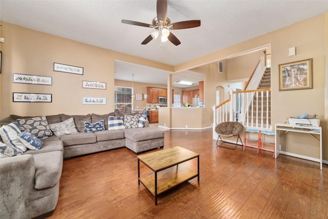 living room featuring ceiling fan, wood-type flooring, and a textured ceiling