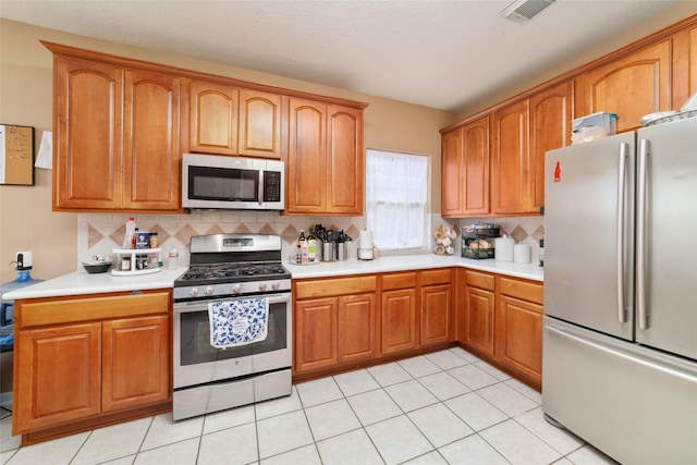 kitchen featuring appliances with stainless steel finishes, backsplash, and light tile patterned floors