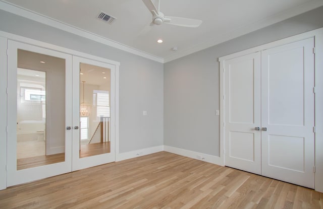 unfurnished bedroom featuring crown molding, light hardwood / wood-style flooring, ceiling fan, and french doors