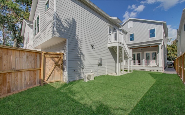 rear view of house with a balcony, a lawn, and ac unit