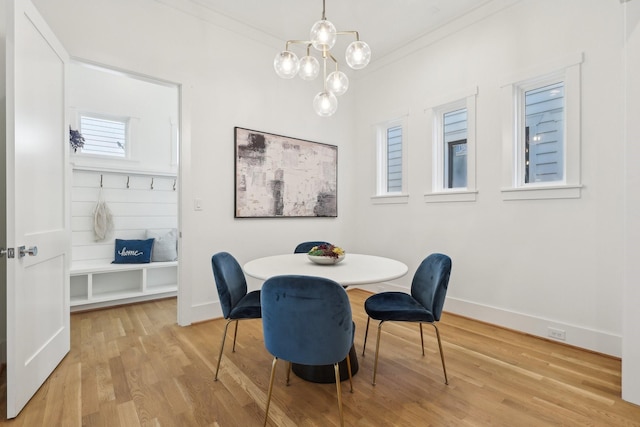 dining area with crown molding and light hardwood / wood-style floors