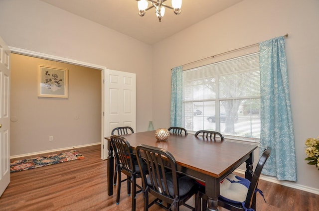 dining space with an inviting chandelier, vaulted ceiling, and hardwood / wood-style flooring