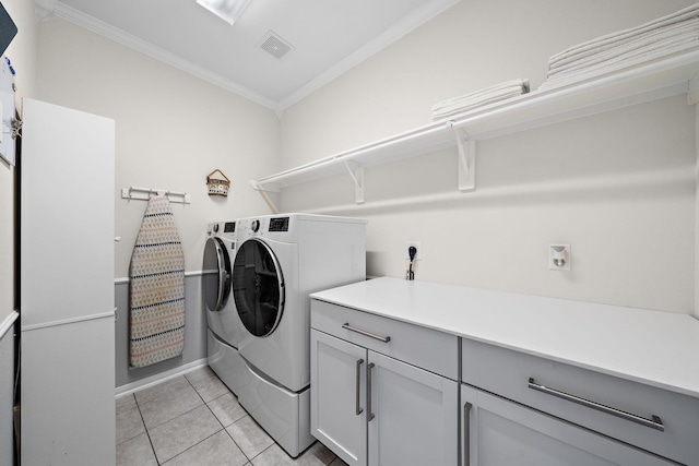 laundry room with independent washer and dryer, cabinets, ornamental molding, and light tile patterned floors