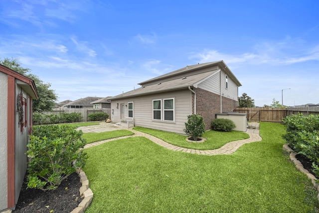 rear view of property with a lawn and a patio