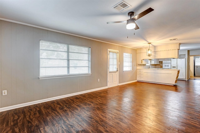 unfurnished living room featuring dark hardwood / wood-style flooring, ceiling fan, and crown molding