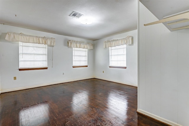 unfurnished room with dark wood-type flooring