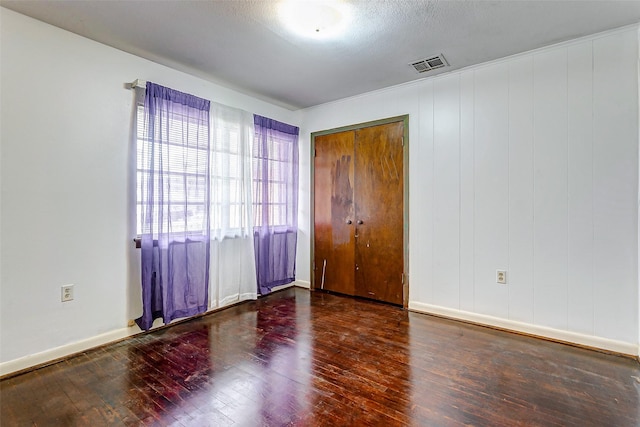 empty room featuring dark hardwood / wood-style floors and a textured ceiling