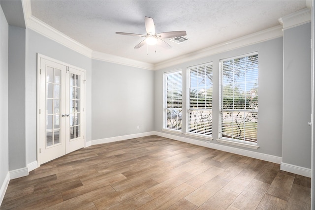 spare room with french doors, crown molding, ceiling fan, a textured ceiling, and wood-type flooring