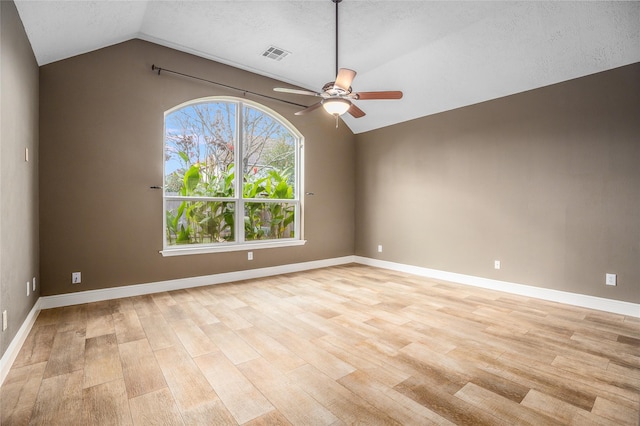 unfurnished room with ceiling fan, lofted ceiling, a textured ceiling, and light hardwood / wood-style flooring