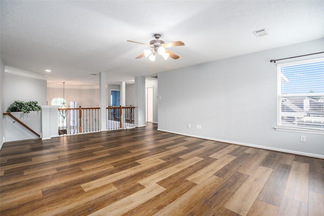 unfurnished room with ceiling fan with notable chandelier, wood-type flooring, and a textured ceiling