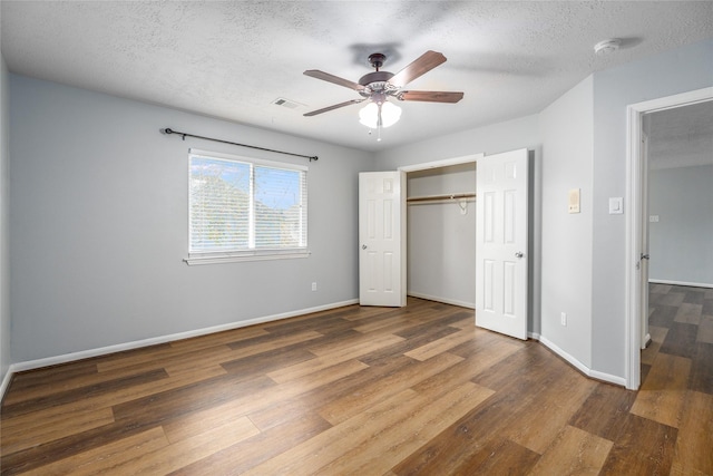 unfurnished bedroom with dark hardwood / wood-style flooring, a textured ceiling, and ceiling fan