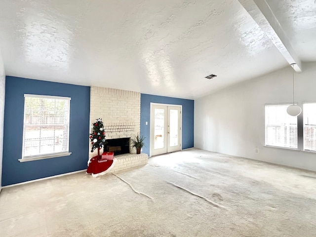 living room featuring carpet flooring, french doors, lofted ceiling with beams, a textured ceiling, and a fireplace