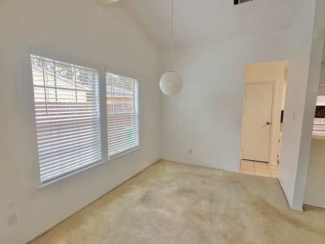 spare room with light carpet and high vaulted ceiling