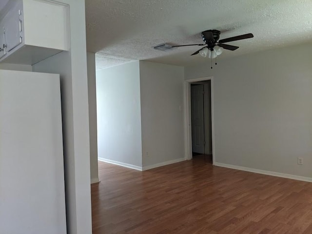 spare room with ceiling fan, hardwood / wood-style floors, and a textured ceiling