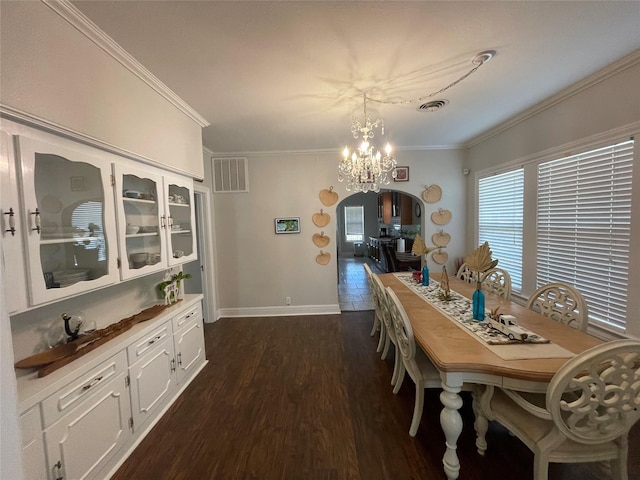 dining room featuring ornamental molding, dark wood-type flooring, and an inviting chandelier