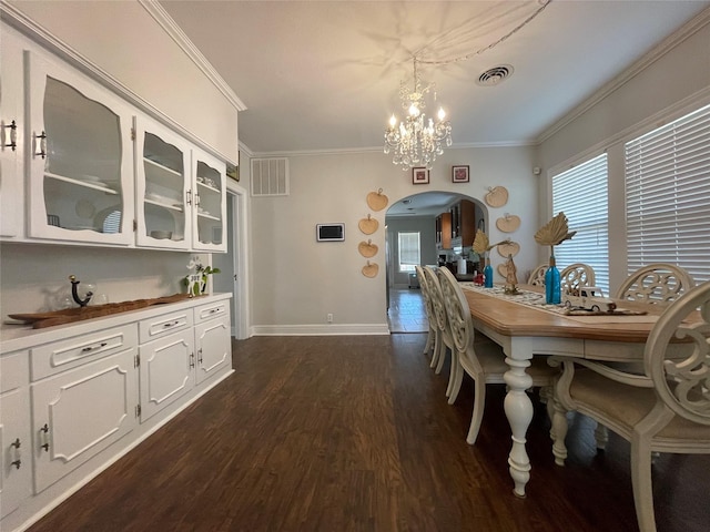 dining space featuring dark hardwood / wood-style flooring, ornamental molding, and a notable chandelier