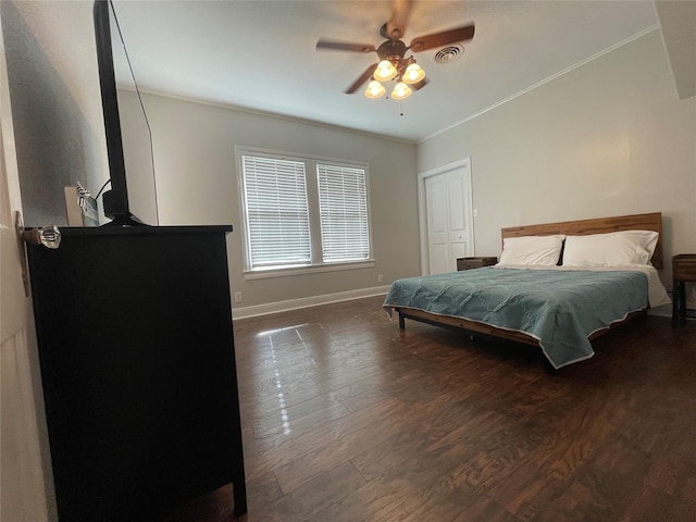 bedroom featuring ceiling fan, crown molding, dark wood-type flooring, and a closet