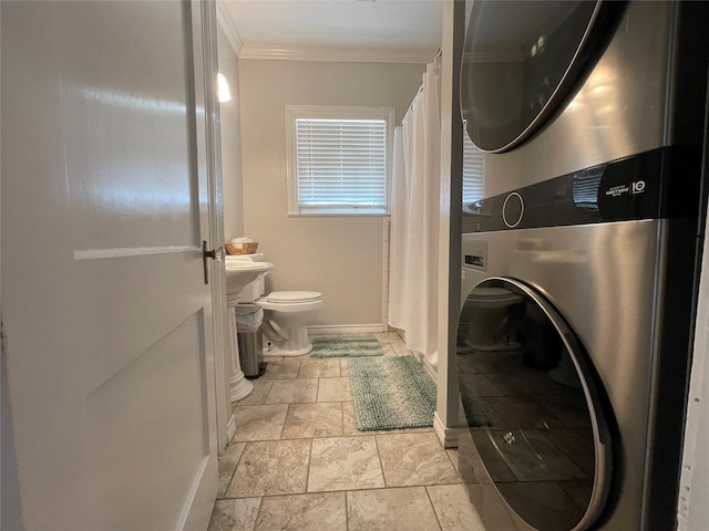 laundry area with stacked washer and dryer and ornamental molding