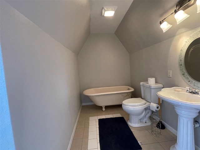 bathroom with toilet, tile patterned floors, vaulted ceiling, and a tub