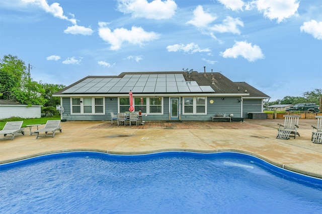 back of house with solar panels and a patio