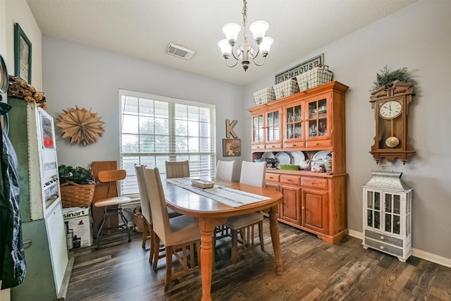 dining area with dark hardwood / wood-style flooring and an inviting chandelier