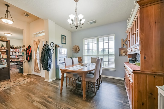 dining space featuring dark hardwood / wood-style floors and an inviting chandelier