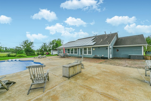 rear view of house featuring a patio and solar panels