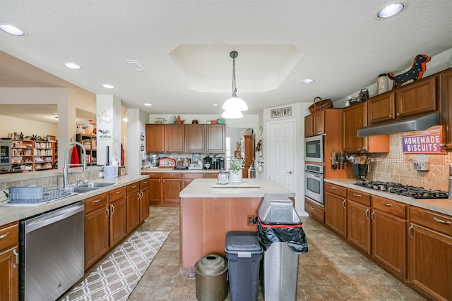 kitchen with sink, tasteful backsplash, decorative light fixtures, a kitchen island, and appliances with stainless steel finishes