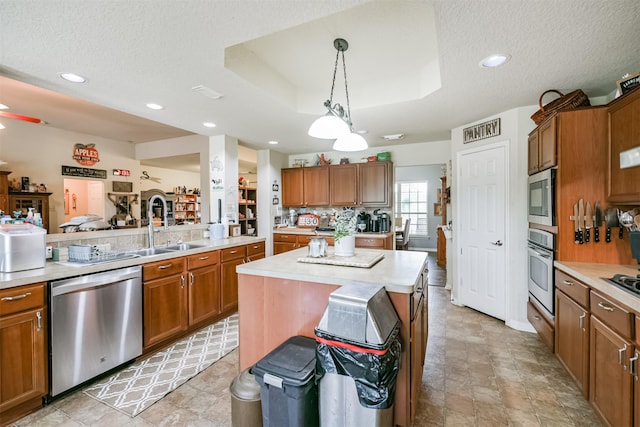 kitchen featuring tasteful backsplash, a textured ceiling, stainless steel appliances, decorative light fixtures, and a kitchen island