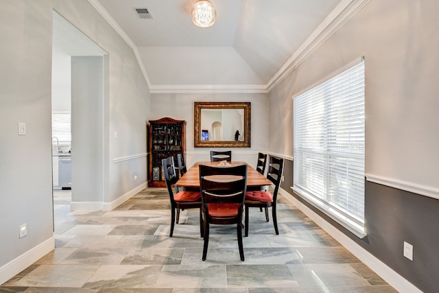 dining space featuring crown molding and lofted ceiling